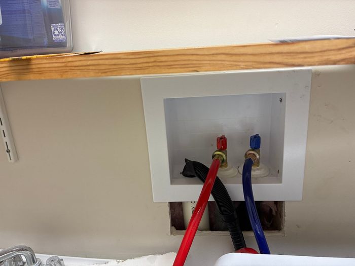 Washing machine outlet box with red and blue water supply lines, from a Durbin Plumbing job