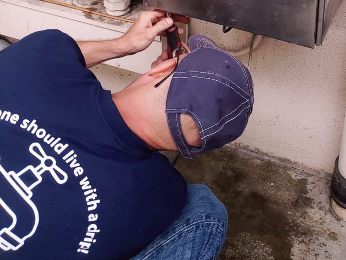 Durbin Plumbing technician in the company shirt that reads No One Should Live With a Drip